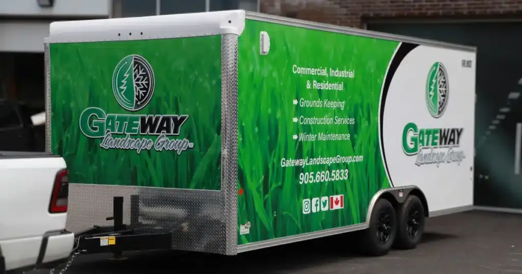 Gateway Landscape Group green trailer wrap after installation, coming out of the garage. From the front view.
