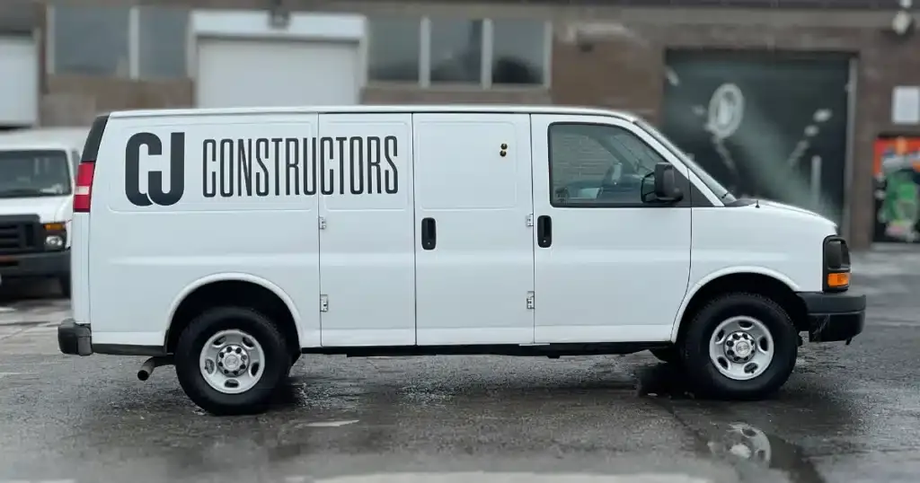 CJ Constructors Chevy Express van after the design and installation process of their van graphics. From the passenger side view.