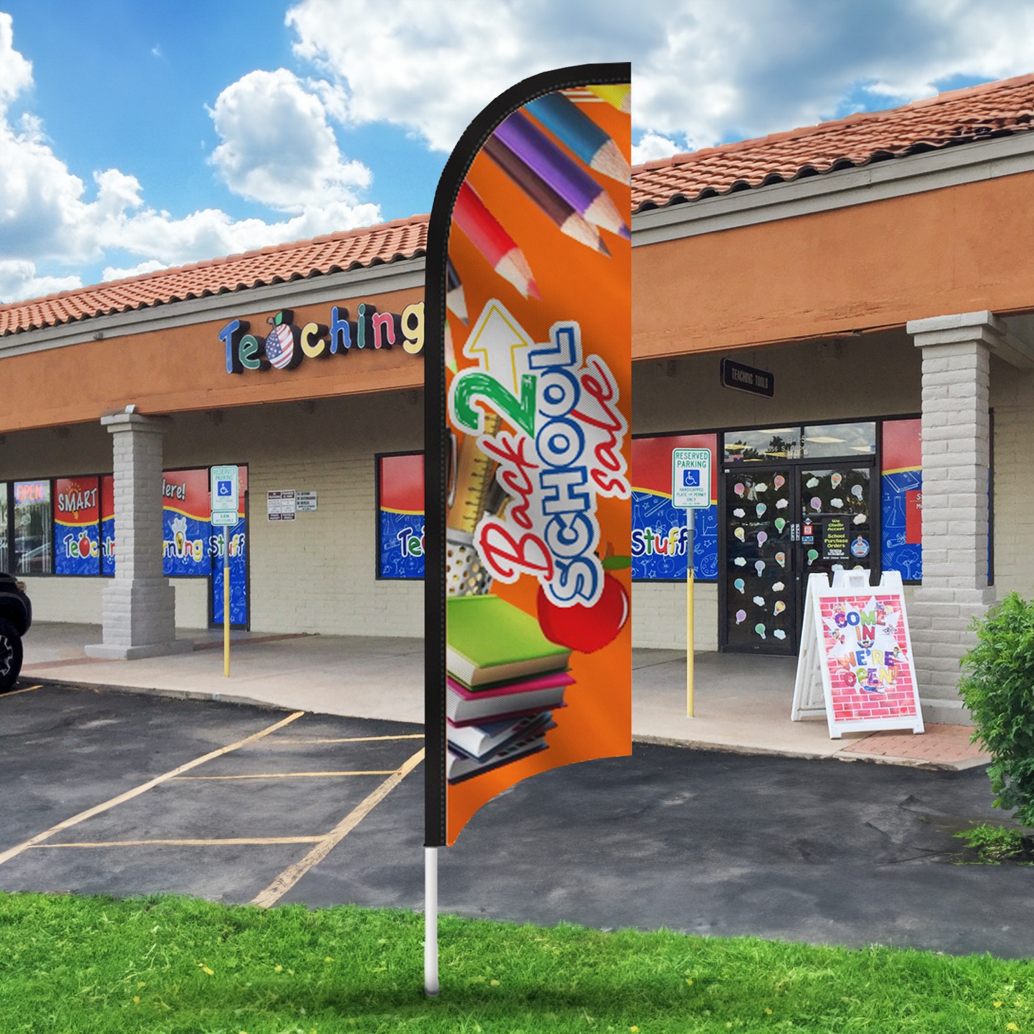 Feather flag advertising "Back to School Sale" in front of a teaching supplies store, featuring colorful graphics with books