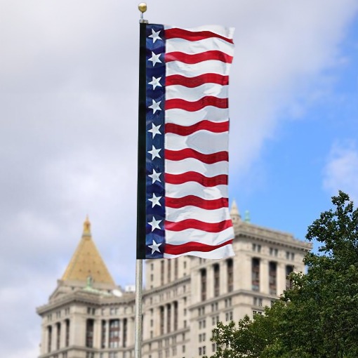 American flag with red and white stripes and blue field featuring white stars, displayed on a flagpole against a backdrop of