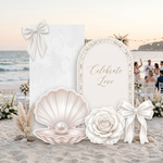 Pearl & Rose Wedding Backdrop Set – marble panel and pearl arch backdrops with seashell, white rose and satin bow standees outdoor beach wedding setup