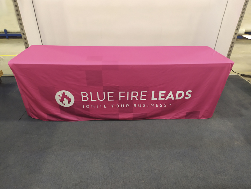 Bright pink table throw with white Blue Fire Leads company logo centered on front side.