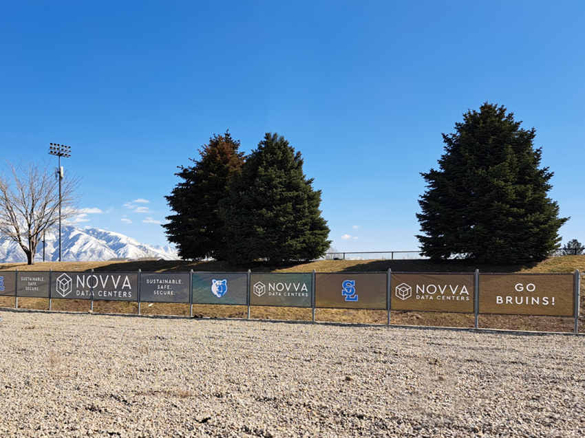 Banners across a long stretch chain link fence.