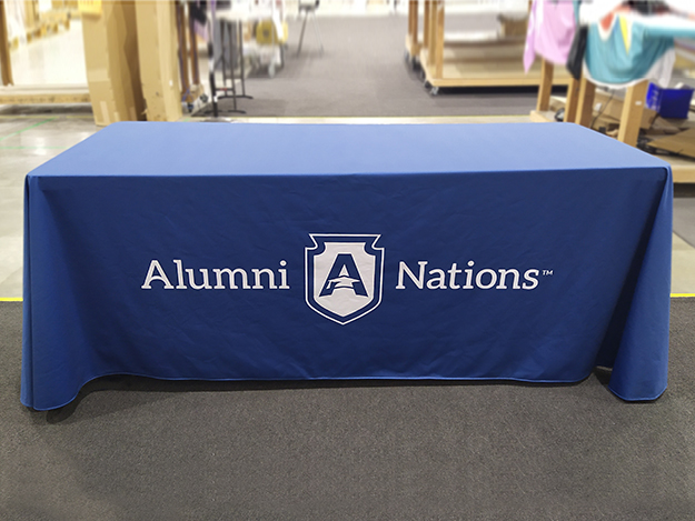 Royal blue table cloth with Alumni Nation logo.