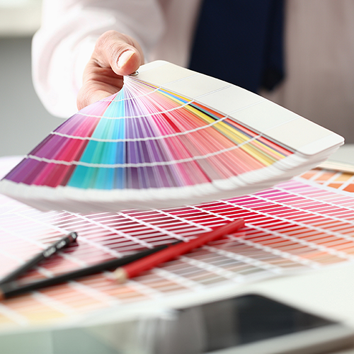 Hand holding out a color book of color swatches.