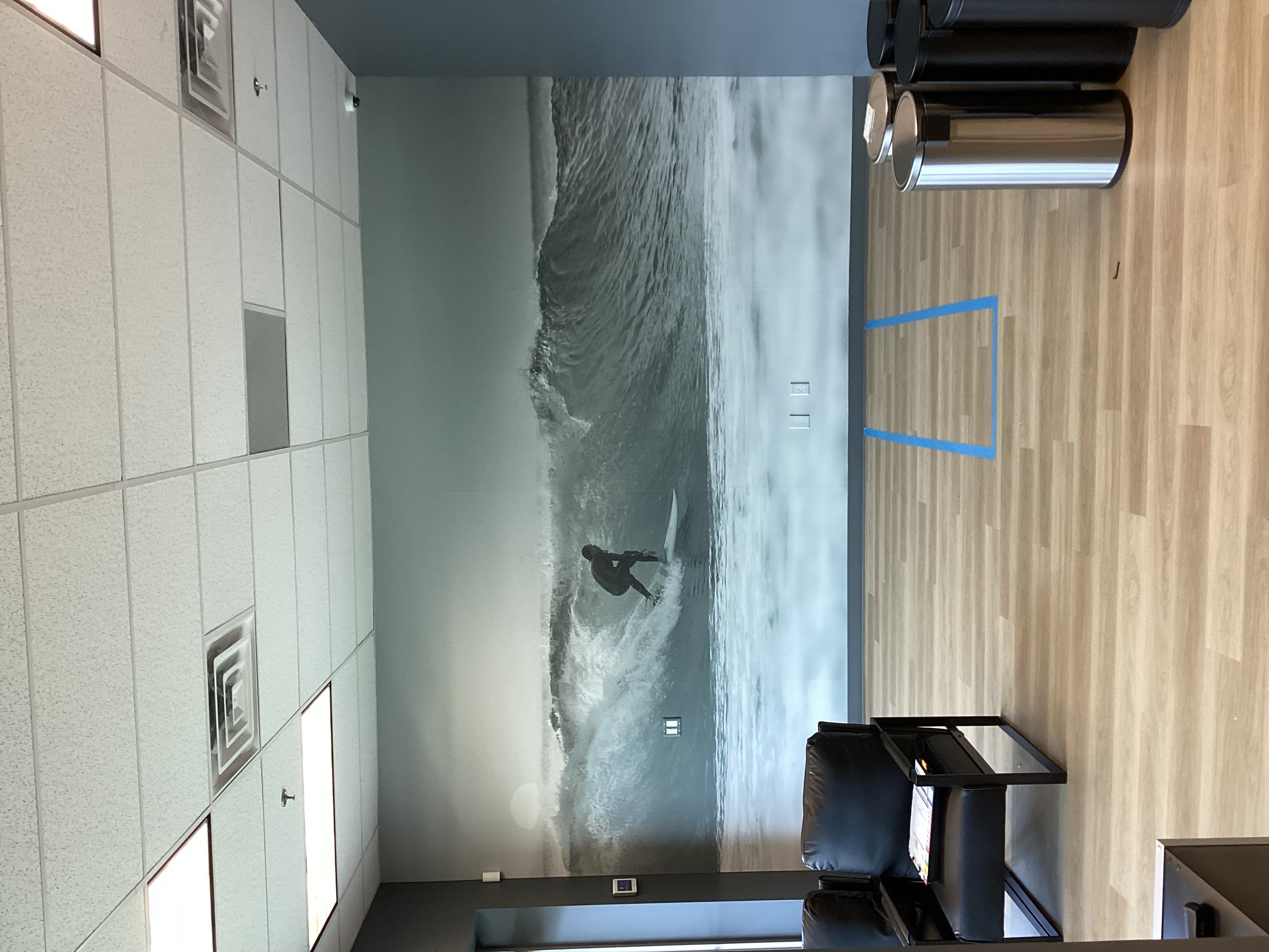 Interior wall mural featuring a surfer riding a large wave.