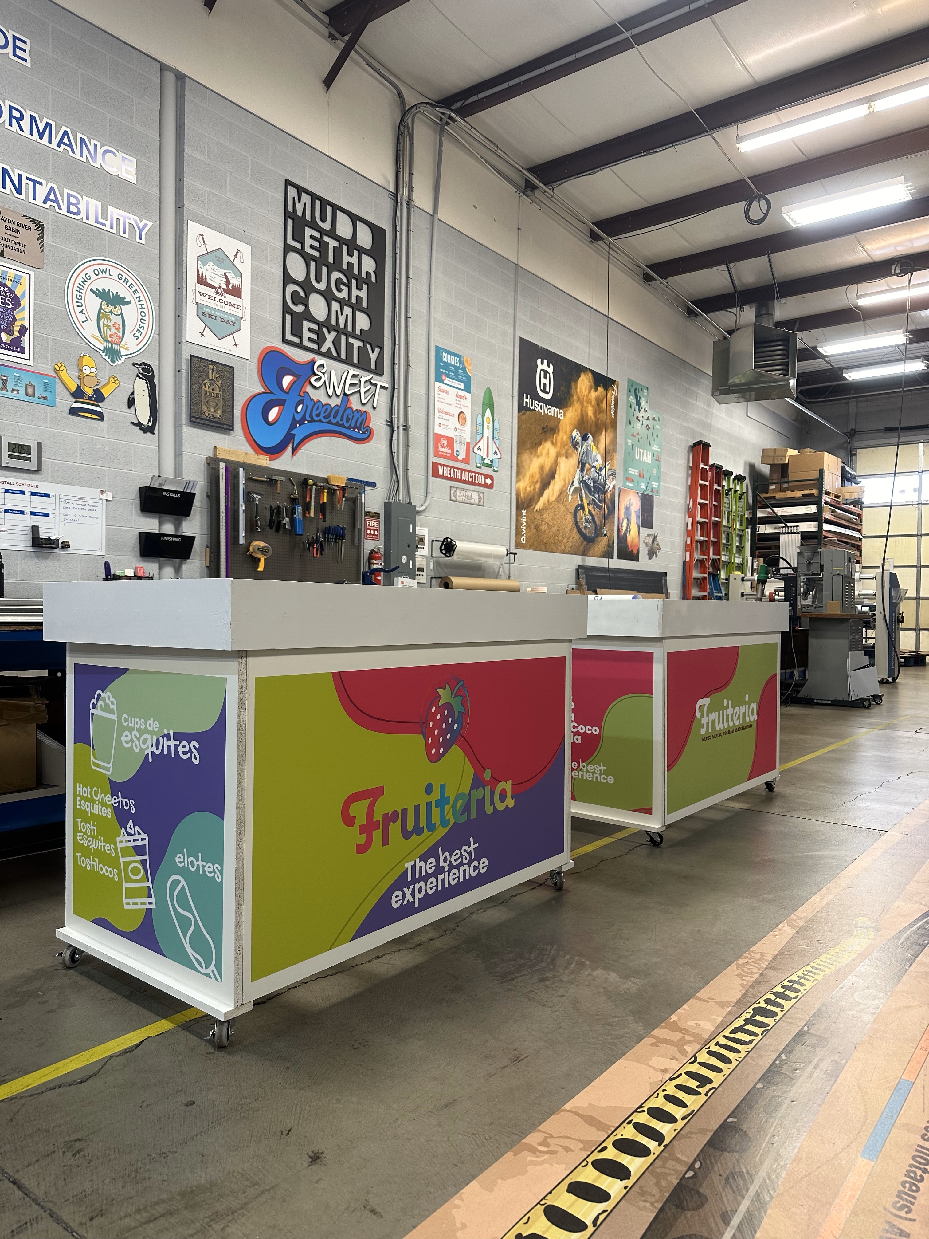 Two food serving stands with vinyl decal on all sides.