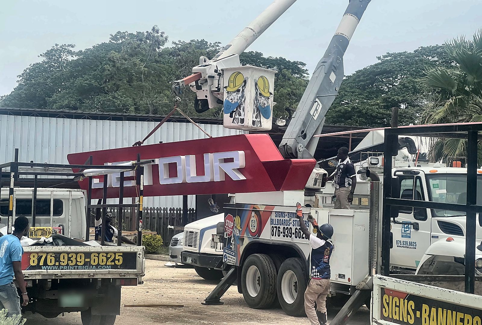 Print Big bucket truck and crew lifting the red JETOUR identification sign into place