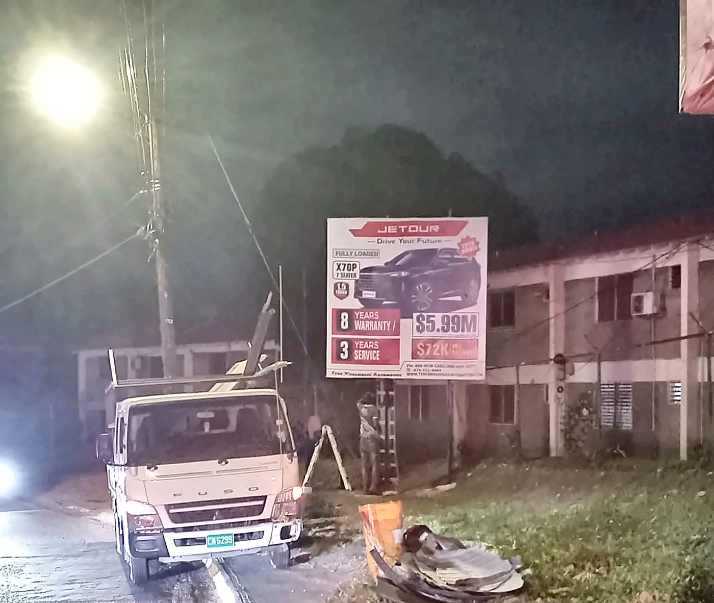 Print Big truck and crew installing a Jetour mini-board at night