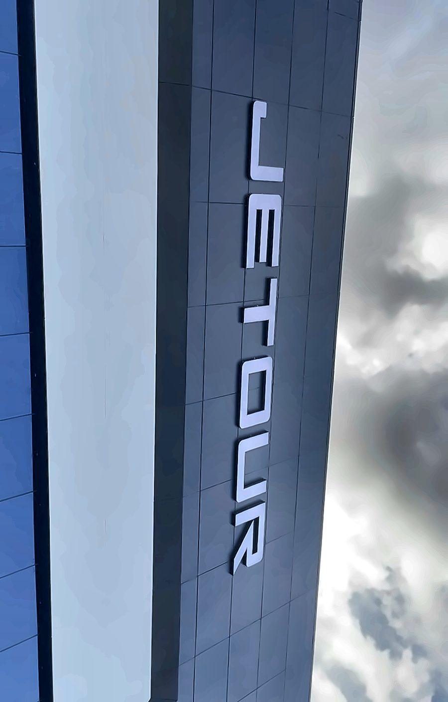 Vertical JETOUR blade lettering on the showroom tower