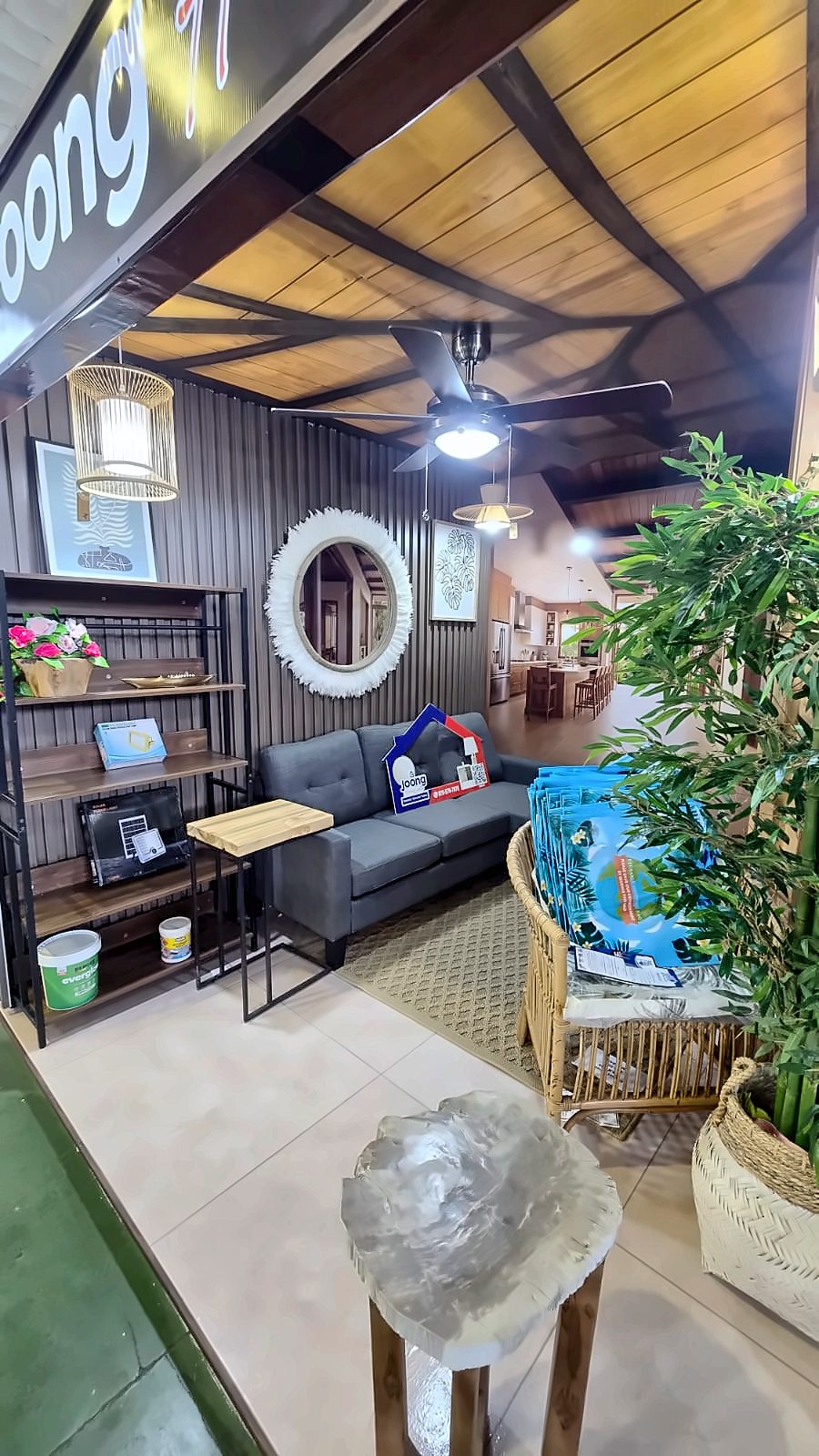 Living room set inside the JOONG booth with a slatted feature wall, timber-look ceiling and ceiling fan