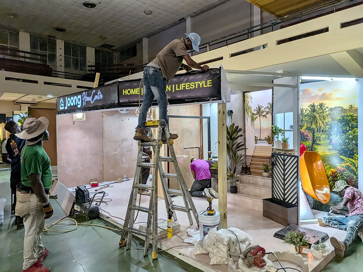 Installer on a ladder fitting the JOONG fascia sign