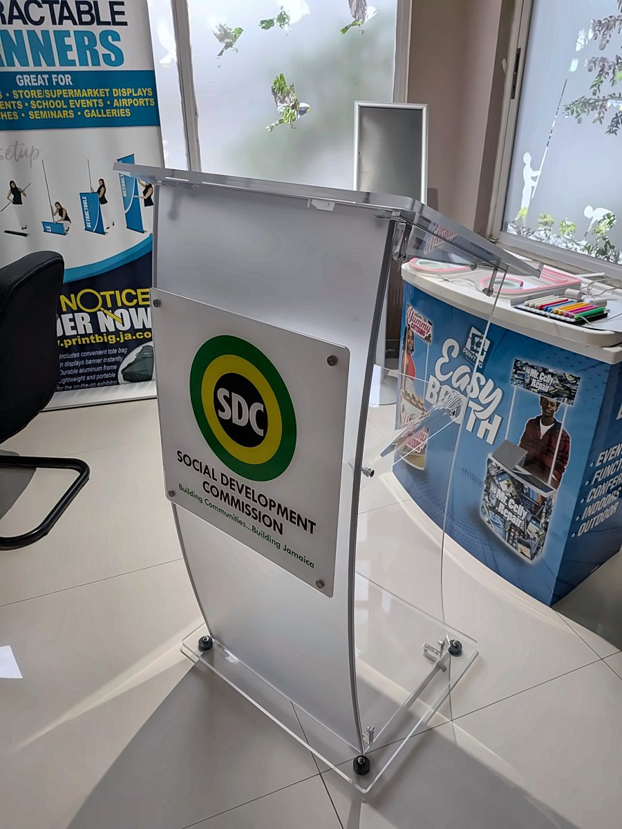 Clear acrylic lectern with the Social Development Commission logo