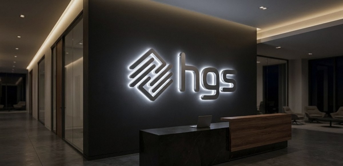 Halo-lit silver logo glowing on a dark lobby wall, HGS, made by Print Big